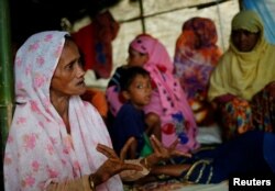 FILE - Shamsun Nahar, 60, a Rohingya widow who fled from Kha Maung Seik village of Myanmar to Bangladesh alone, whose 30-year-old son is missing, tells her story at Kutupalang Makeshift Camp in Cox’s Bazar, Bangladesh, Sept. 4, 2017.