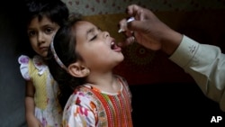A health worker gives a polio vaccine to a girl in Lahore, Pakistan, April 9, 2018. A Pakistani official said authorities launched a new polio vaccination drive, aiming to reach 38.7 million children younger than 5.