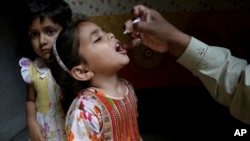 ARSIP - Seorang pekerja kesehatan memberikan vaksin polio ke seorang anak perempuan di Lahore, Pakistan, Senin, 9 April 2018 (foto: AP Photo/K.M. Chaudary)
