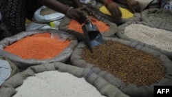 Indian vendors arrange grain for display at their shop in Kolkata, August 26, 2013.