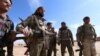 Syria Democratic Forces fighters carry their weapons in a village on the outskirts of al-Shadadi town, Hasaka countryside, Syria, Feb. 19, 2016.