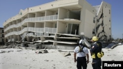 Members of the Federal Emergency and Management Agency's search and rescue team, Task Force 1 from Texas, plan their search of the Winfield Resort condominium September 17, 2004 after Hurricane Ivan struck the area in Orange Beach, Alabama.