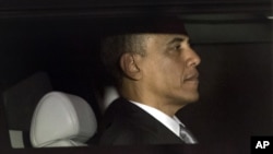 President Barack Obama is seen through the window of a limo as he returns to the White House for the first time since his victory on election day, in Washington, Nov. 7, 2012. 