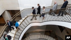 FILE - Members of Congress descend to a secure area at the Capitol to meet with national security officials for an intelligence briefing about the decision to swap captive Army Sgt. Bowe Bergdahl for five detainees at Guantanamo Bay, in Washington, June 9, 2014.