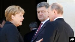 German Chancellor Angela Merkel, left, Russian President Vladimir Putin, right, and Ukrainian president-elect Petro Poroshenko, center, talk after a group photo in NOrmandy, France, June 6, 2014.