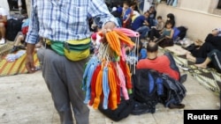 Cep telefonları su geçirmesin diye mültecilere balon satan bir sokak satıcısı