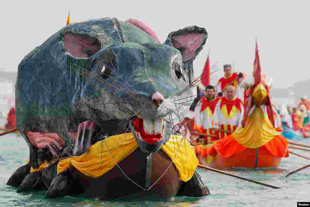 Venetians row during the masquerade parade on the Grand Canal during the Carnival in Venice, Italy.