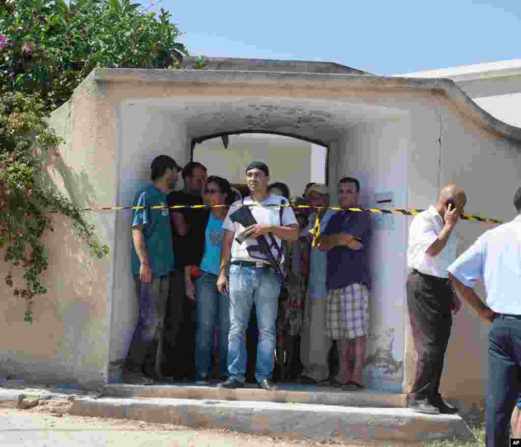 A Tunisian plainclothes police officer secures the house of Mohamed Brahmi after he was shot to death outside his home in Tunis, July 25, 2013.&nbsp;