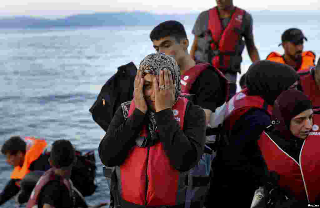 Reaksi seorang perempuan pengungsi Suriah yang menyeberangi Laut Aegea dari Turki, dengan perahu karet yang penuh sesak, ketika tiba di pantai Yunani, Lesbos.