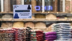 A Ministry for the Propagation of Virtue and the Prevention of Vice sitcker reading "According to Sharia Law, Muslim women must do the Hijab (covering head)" is seen on the window of a shop in Kabul, Jan. 7, 2022.