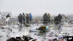 Karyawan Kementerian Darurat Rusia memeriksa reruntuhan pesawat yang jatuh di bandara Rostov-on-Don, sekitar 950 kilometers sebelah selatan Moskow (19/3). 