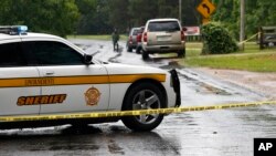Un vehículo policial bloquea una calle en Brookhaven, Mississippi, donde varias personas fueron asesinadas el sábado por la noche.