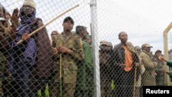 Congolese M23 rebel fighters gather inside an enclosure after surrendering to Uganda's government at Rugwerero village in Kisoro district, 489km (293 miles) west from Uganda capital Kampala, Nov. 8, 2013. 