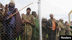 Congolese M23 rebel fighters gather inside an enclosure after surrendering to Uganda's government at Rugwerero village in Kisoro district, 489km (293 miles) west from Uganda capital Kampala, Nov. 8, 2013. 