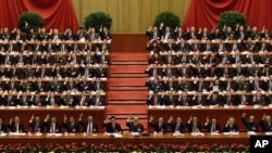 China's leaders raise their hands to show approval for a work report at the closing ceremony for the 18th Communist Party Congress, Beijing, November 14, 2012. 