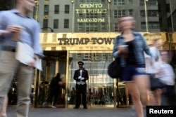 FILE - A doorman stands as people walk past the Trump Tower in New York, May 23, 2016.