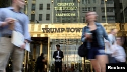 FILE - A doorman stands as people walk past the Trump Tower in New York, May 23, 2016.