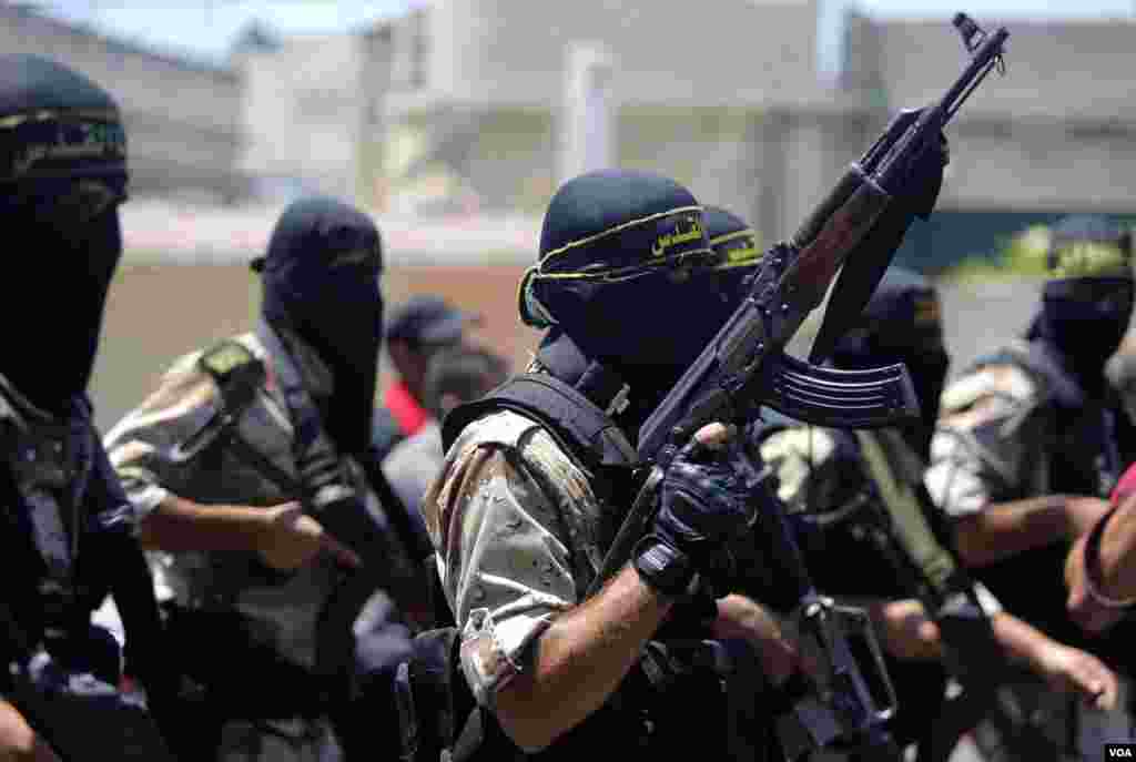 Masked militants of the Islamic Jihad group march during the funeral of their comrade Shaaban Al-Dahdouh, whose body was found under the rubble Tuesday in Gaza City, Aug. 6, 2014.