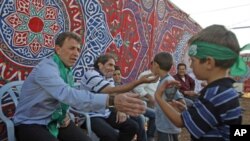 Freed Palestinian prisoner Nael Barghouti (L), who served 33 years in an Israeli jail, more time than any other Palestinian released in a trade for Israeli soldier Gilad Shalit, greets a child along with Fakhri Barghouti (C), who also was released, at Coo