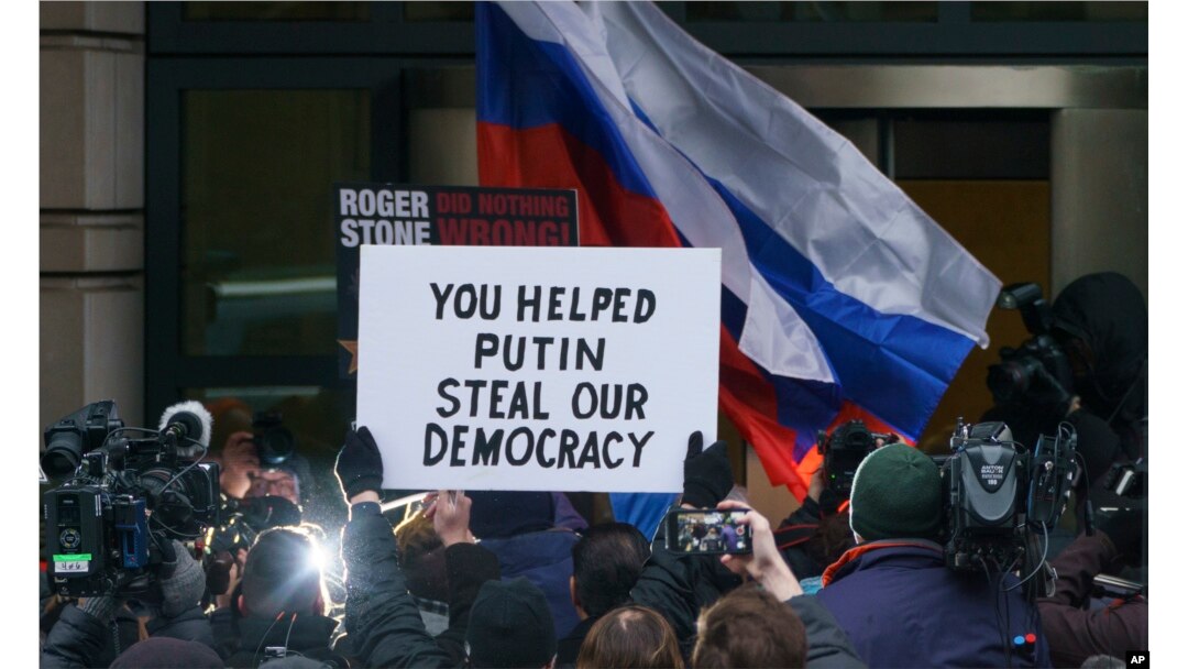 FILE - Former adviser for President Donald Trump, Roger Stone, is surrounded by protesters and supporters, some with signs and Russian flags, as he arrives at federal court in Washington, Jan. 29, 2019.