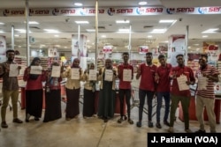 Staff of Sena supermarket hold signs supporting the revolution while refusing to work during a strike, in Khartoum, Sudan, May 28, 2019.