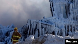 A firefighter looks on at the seniors residence Residence du Havre after a fire in L'Isle Verte, Quebec, January 23, 2014. (Reuters) 