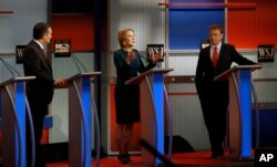 Carly Fiorina, center, speaks as Ted Cruz, left, and Rand Paul, right, listen during a Republican presidential debate at Milwaukee Theatre, in Milwaukee, Nov. 10, 2015.