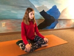 Aeva Schifferli, 12, menunjukkan latihan pernapasan yang menghilangkan stres di studio yoga ibunya di East Aurora, NY, 14 Mei 2019. (Foto: AP)