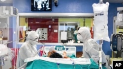 A patient writes a note to medical staffers, in the ICU of the Bassini Hospital, in Cinisello Balsamo, near Milan, Italy, Tuesday, April 14, 2020. 