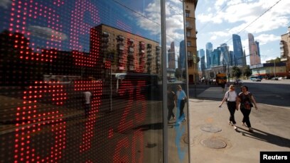 Ruble Slump Hits Russians Wallets Not Their Support For Putin Pedestrians Walk Past An Electronic Board Showing Currency Exchange Rates Of The U S Dollar And Euro