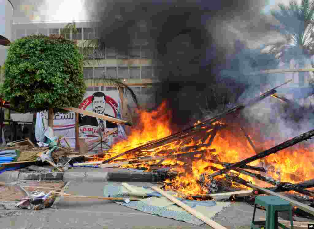 Makeshift wooden huts burn at a sit-in camp set up by supporters of ousted Islamist President Mohammed Morsi as Egyptian security forces clear the camp near Cairo University in Cairo&#39;s Giza district, Egypt, August 14, 2013.&nbsp;