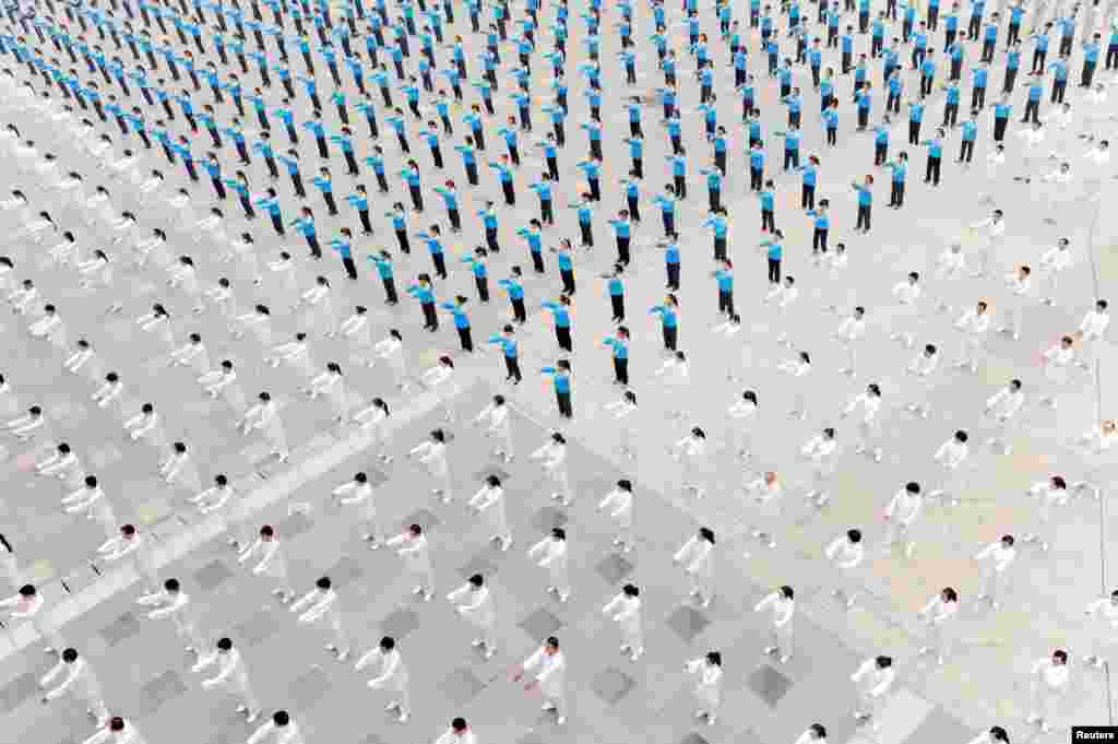 People practice tai chi at a square in Qinyang, Henan province, China.