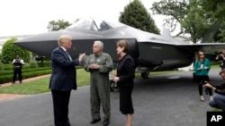 Президент США Трамп спілкується з президентом авіабудівної компанії Lockheed Martin Мерілін Гьюсон та льотчиком Аланом Норманом на тлі F-35. Липень 2018-го року.