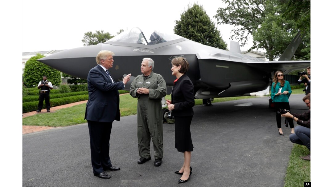 President Donald Trump talks with Lockheed Martin president and CEO Marilyn Hewson and director and chief test pilot Alan Norman in front of a F-35 as he participates in a "Made in America Product Showcase" at the White House, July 23, 2018.