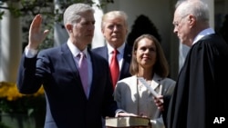 President Donald Trump watches as Supreme Court Justice Anthony Kennedy administers the judicial oath to Judge Neil Gorsuch during a re-enactment in the Rose Garden of the White House White House in Washington, April 10, 2017. 