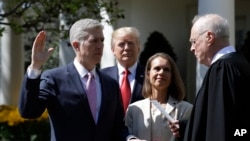 President Donald Trump watches as Supreme Court Justice Anthony Kennedy administers the judicial oath to Judge Neil Gorsuch during a re-enactment in the Rose Garden of the White House White House in Washington, April 10, 2017.