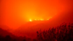 Flames from the KNP Complex Fire burn along a hillside above the Kaweah River in Sequoia National Park, Calif., on Sept. 14, 2021.