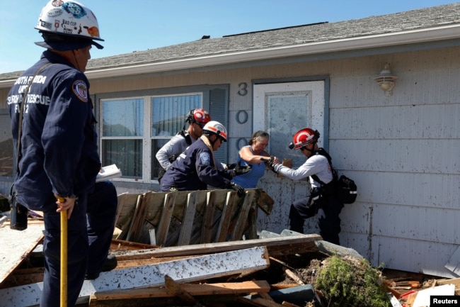 Bianna Kelsay is rescued from a building damaged by Hurricane Michael in Mexico Beach, Florida, U.S., Oct. 11, 2018.