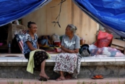 Dua perempuan lansia mengobrol di pusat evakuasi sementara untuk warga yang tinggal di dekat Gunung Agung, gunung berapi pada tingkat siaga tertinggi, di Manggis, Bali, 1 Oktober 2017.