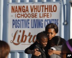 Mme Obama embrassant des jeunes dans projet communautaire à Soweto