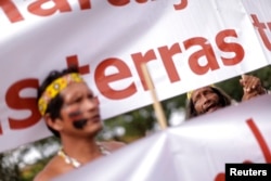 FILE - Indigenous Indians protest in front of the Planalto Palace in Brasilia, Brazil, Nov. 26, 2014.