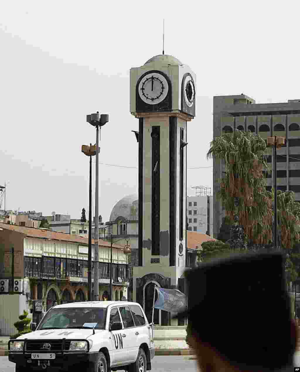 UN observers in Syria drive through the central Clock Tower Square in Homs following a visit to the flashpoint city's Khalidiya district. Both sides in the Syrian conflict are violating a ceasefire as a rights group accused the regime of committing atroci