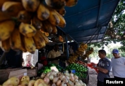 FILE - People buy food at a privately-licensed fruit and vegetable stall in Havana, Cuba, Feb. 1, 2012.