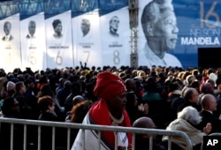 Members of the public sit beneath a banner of former President Nelson Mandela (R) where former U.S. President Barack Obama delivered his speech at the 16th Annual Nelson Mandela Lecture at the Wanderers Stadium in Johannesburg, South Africa, July 17, 2018