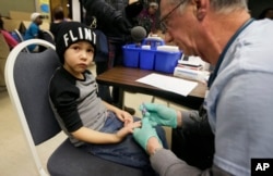 FILE - Registered Nurse Brian Jones draws a blood sample from Grayling Stefek, 5, at the Eisenhower Elementary School, in Flint, Mich., Jan. 26, 2016. The students were being tested for lead after the metal was found in the city's drinking water.