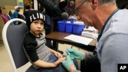 Registered Nurse Brian Jones draws a blood sample from Grayling Stefek, 5, at the Eisenhower Elementary School, in Flint, Mich., Jan. 26, 2016. The students were being tested for lead after the metal was found in the city's drinking water. 