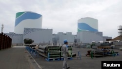 工人走过日本西南部的仙台核电站的反应堆建筑（资料照片）