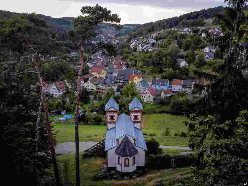 A chapel stands on a hill over the city of Mespelbrunn in the Spessart region, Germany, Aug. 29, 2020.