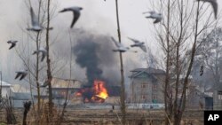 Flames and smoke billows from a residential building where militants are suspected to have taken refuge during a gun battle in Pulwama, south of Srinagar, Indian controlled Kashmir, Monday, Feb. 18, 2019. 