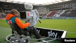 FILE - TV camera operator with the Sky television team checks his camera before a soccer match in Hamburg, August 28, 2010.